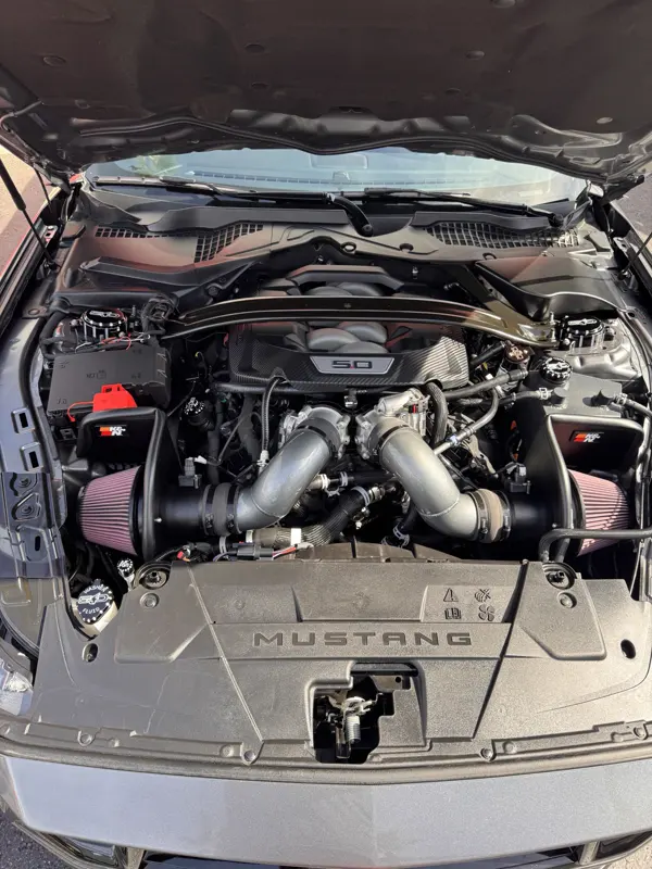 Engine bay with dual K&N intakes, UPR Howling Coyote caps, and the 5.0 cover