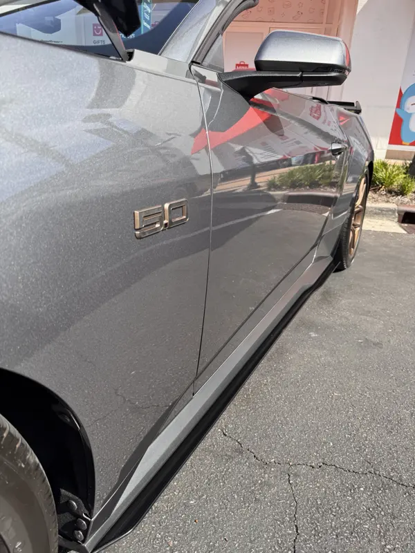 Driver side with 5.0 fender badge and black side skirt